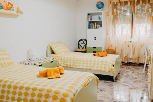 a bedroom with two beds with orange and white sheets at I due ponti in Molfetta
