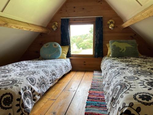 two beds in a room with a window at The charming, bright stable in Neuilly-le-Dien