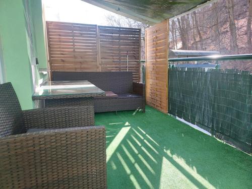 a screened in porch with two benches and green grass at Apartment Lilianna in Karlovy Vary