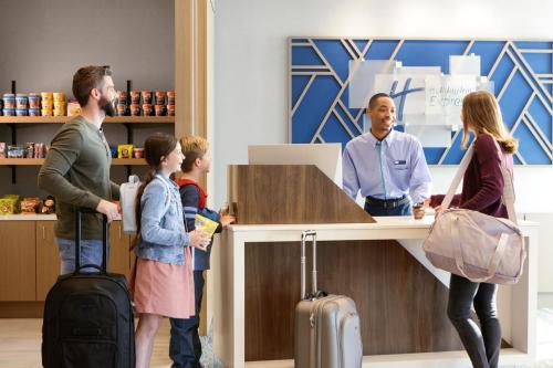 a group of people standing around a counter with luggage at Holiday Inn Express Richmond-Brandermill-Hull Street by IHG in Brandermill