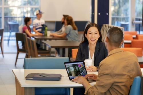 a woman and a man sitting at a table with a laptop at Holiday Inn Express Richmond-Brandermill-Hull Street by IHG in Brandermill