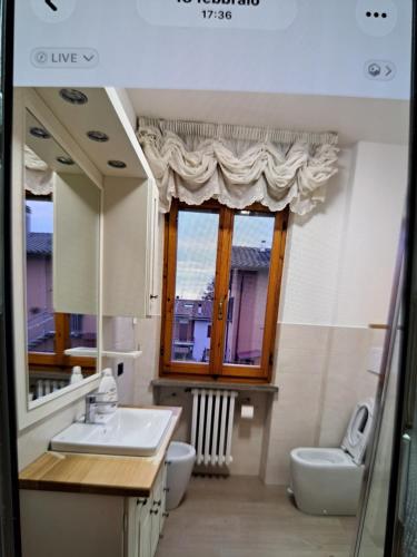 a bathroom with a sink and a toilet and a window at appartamento yuliet in Città di Castello