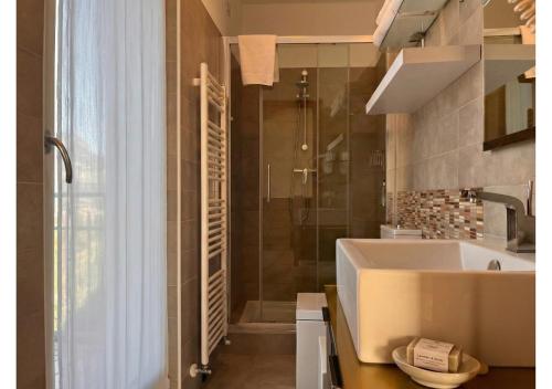 a bathroom with a sink and a shower and a tub at Hotel Isola Verde in Nago-Torbole