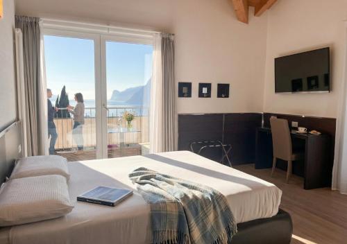 a hotel room with a bed and a large window at Hotel Isola Verde in Nago-Torbole