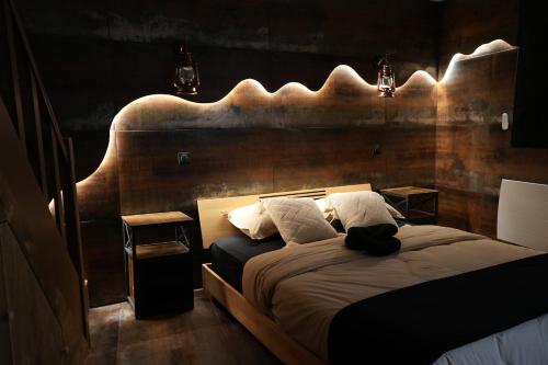 a bedroom with a bed with a large wooden headboard at Cabin 13 Immersive Suite with Balneotherapy in Boulogne-sur-Mer