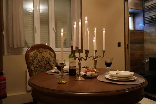 a dining room table with candles and plates and wine bottles at Cabin 13 Immersive Suite with Balneotherapy in Boulogne-sur-Mer