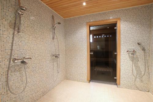 a bathroom with two showers and a glass door at Pielusrinne in Hattusaari