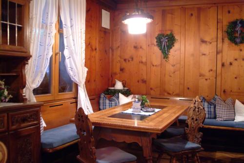 a dining room with a wooden table and chairs at Sporthotel Sonne in Schruns-Tschagguns
