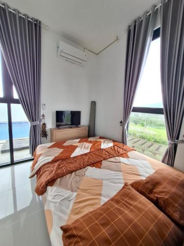 a bedroom with a bed and a large window at Athara Residence in Tlekung