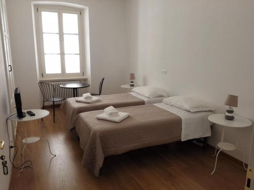 a white room with two beds and a window at Palazzo Brigido Apartment in Trieste