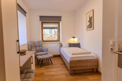 a small room with a bed and a chair at Chaplin in Kempten