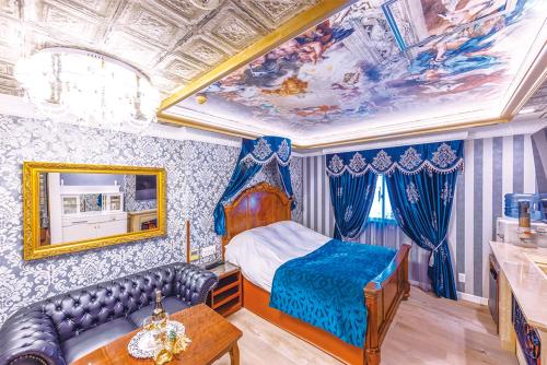 a bedroom with a bed and a couch and a ceiling at Hotel Shiro No Kyuden in Ibaraki