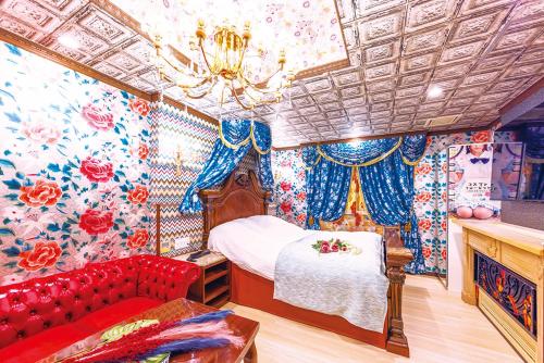 a bedroom with a bed and a red couch at Hotel Shiro No Kyuden in Ibaraki