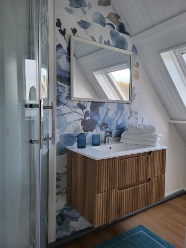 a bathroom with a sink and a mirror at Les 3 Nuances in Saint-Suliac