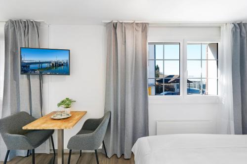 a bedroom with a table and a bed and a window at Hotel Schiff in Horn