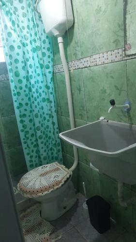 a bathroom with a toilet and a sink and a tub at Pequena e graciosa in Estação Senador Camará