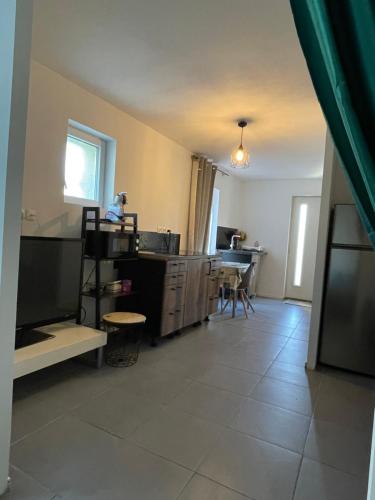 Chez Cassi في Saint-Nicolas-dʼAliermont: غرفة معيشة مع مطبخ وغرفة طعام