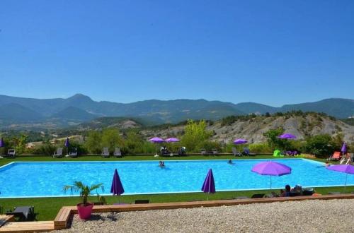 a large swimming pool with umbrellas and people in it at ZEcamping 4 étoiles animaux acceptés animations piscine chauffée in Rosans