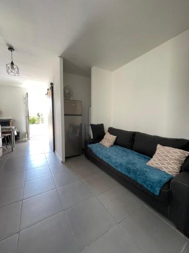 Chez Cassi في Saint-Nicolas-dʼAliermont: غرفة معيشة مع أريكة ومطبخ
