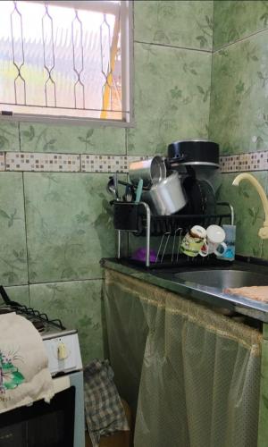 a kitchen with a counter top with a microwave at Pequena e graciosa in Estação Senador Camará