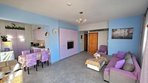 a living room with purple furniture and a kitchen at Mary's Apartment - Close to port, beaches in Kos