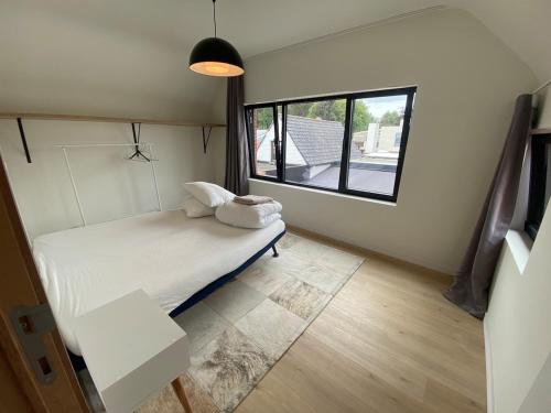 a small room with a bed and a window at Spacious house specially for workers and expats in Maldegem