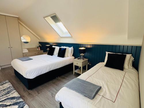 two beds in a room with blue walls at Pier House Luxury Apartment in Dingle