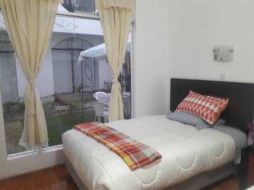 1 dormitorio con 1 cama frente a una ventana en Hospedaje Familiar Rigimark, en Tacna
