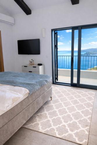 a bedroom with a bed and a view of the ocean at Villa Miramare in Blizikuće