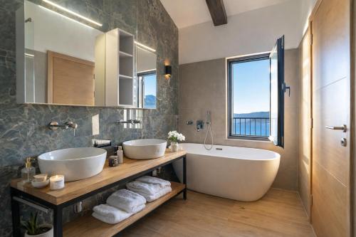 a bathroom with two sinks and a tub and a window at Villa Miramare in Blizikuće