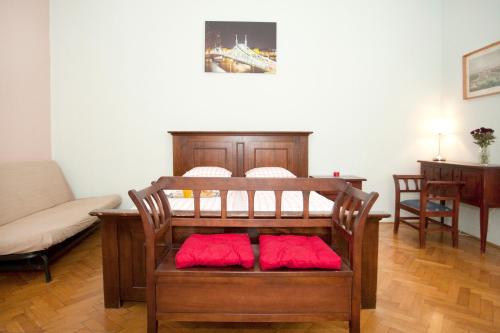 ein Zimmer mit einem Bett mit roten Kissen darauf in der Unterkunft Liana-Luxury And Central Flat in Budapest