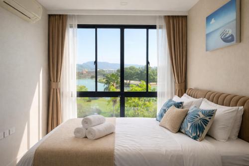 a bedroom with a bed with a large window at Aleksandra Royal Lee in Ban Bo Han