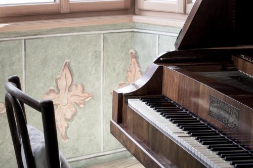 an old piano in a room with a wall at Zum Riesen Historic Refugium in Laces