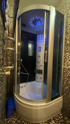 a bathroom with a shower with a large mirror at Bright House in Bila Tserkva