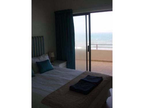 a bedroom with a bed with a view of the ocean at Lazy Lizard 63 in Umdloti