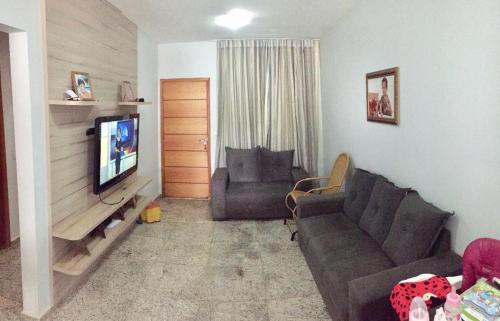 a living room with a couch and a television at Casa mobiliada BR 153 in Aparecida de Goiânia