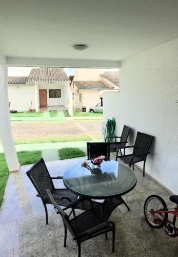 a patio with a table and chairs and a bike at Casa mobiliada BR 153 in Aparecida de Goiânia