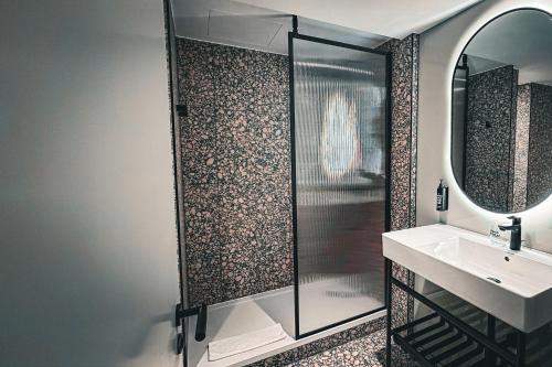 a bathroom with a shower and a sink and a mirror at Village Hotel Reading in Reading
