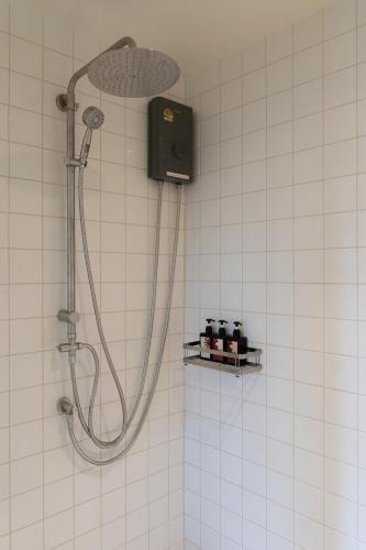 a shower with a shower head in a bathroom at Arunne in Bangkok Yai