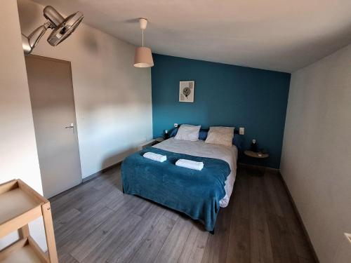 a bedroom with a bed and a blue wall at Mer Méditerranée et Béziers à 10min Parking gratuit in Sauvian
