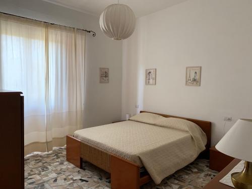 a bedroom with a bed and a large window at Arega Rooms in Villasimius