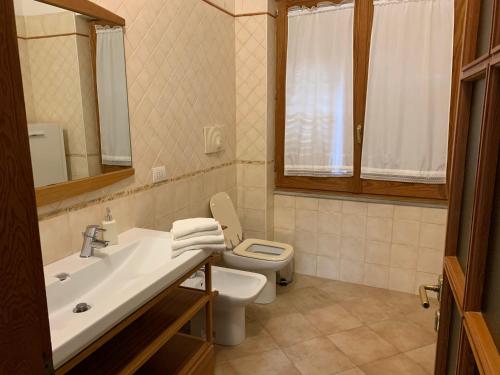 a bathroom with a sink and a toilet and a mirror at Arega Rooms in Villasimius