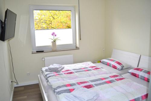 een slaapkamer met een bed voor een raam bij Ferienwohnung Lavendel in Brüggen