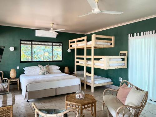 a bedroom with a bed and bunk beds at Jungle Hut - RARE absolute beachfront! in Dundee Beach