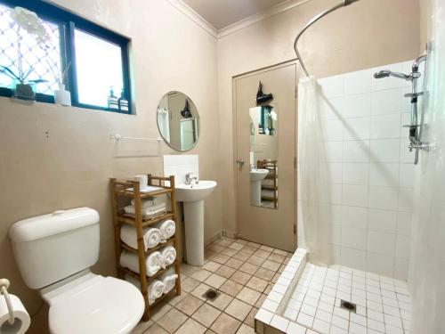 a bathroom with a toilet and a sink and a shower at Jungle Hut - RARE absolute beachfront! in Dundee Beach