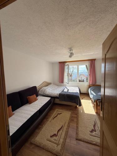 a room with a couch and a bed and a window at Vila AT in Sarajevo