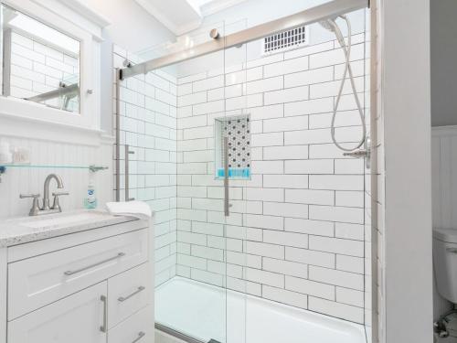 a white bathroom with a shower and a sink at Historic Home with King Bed in High Point