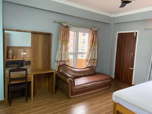 a bedroom with a leather chair and a desk at Hotel The Mint Garden in Pokhara