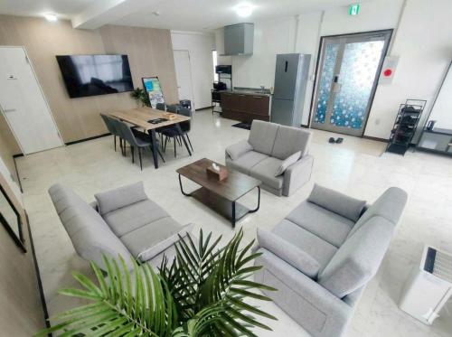a living room with two couches and a table at -Ina Stay Central Hotel-8名宿泊可 伊那市駅徒歩5分 駐車場無料 a sleep8-a 5minute walk from the station-Free parking in Ina