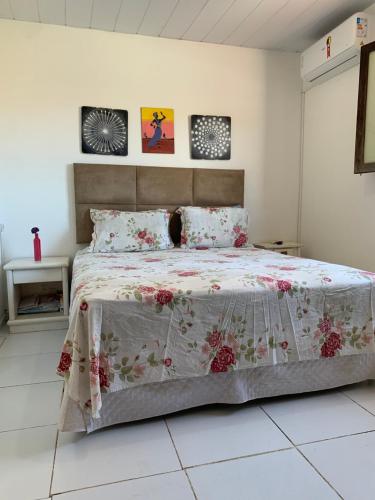 a bedroom with a large bed with a floral bedspread at casa aconchegante proximo a praia in Maceió